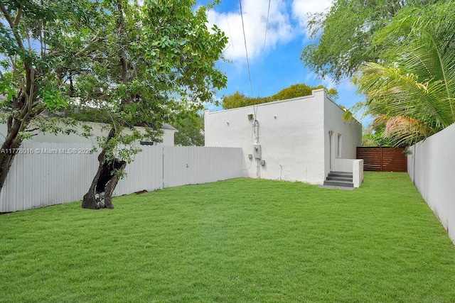 view of yard with a fenced backyard and entry steps