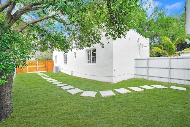 view of yard featuring central air condition unit and fence