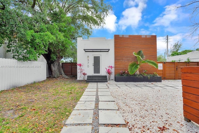view of front of property with stucco siding, fence, and entry steps
