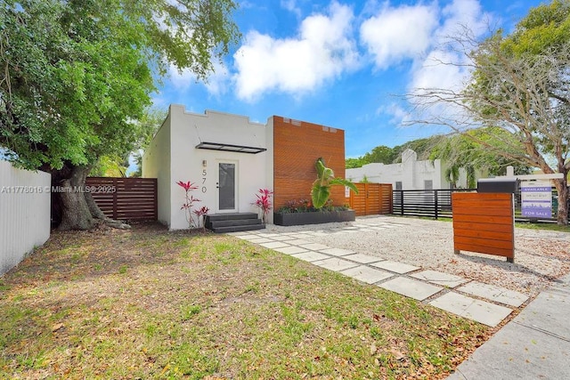 exterior space featuring a gate, stucco siding, fence, and entry steps