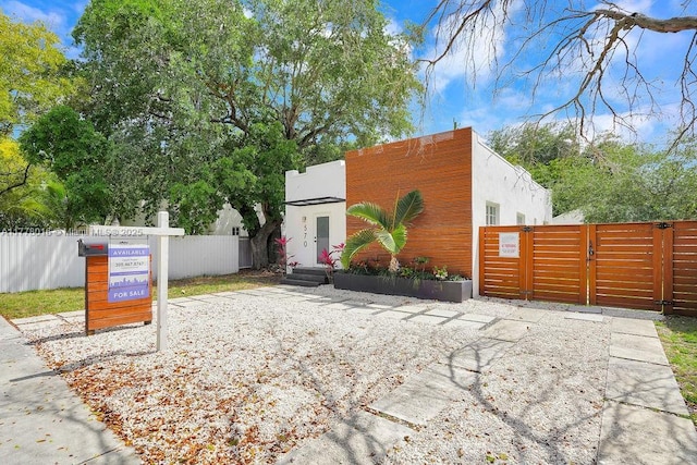 view of front of house featuring a gate, stucco siding, and fence
