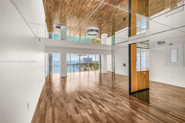 11111 Biscayne Blvd Unit 16G, Miami, FL 33181 - unfurnished living room featuring wood finished floors, baseboards, and a high ceiling