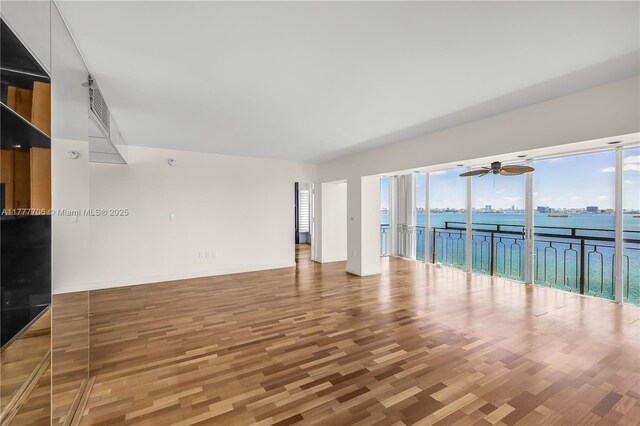 11111 Biscayne Blvd Unit 16G, Miami, FL 33181 - unfurnished living room featuring a water view, ceiling fan, baseboards, and wood finished floors