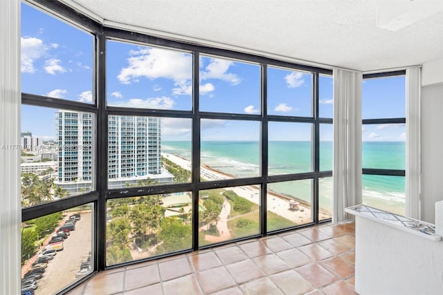 6423 Collins Ave Unit 1607, Miami Beach, FL 33141 - unfurnished sunroom featuring a water view, a view of the beach, and a wealth of natural light