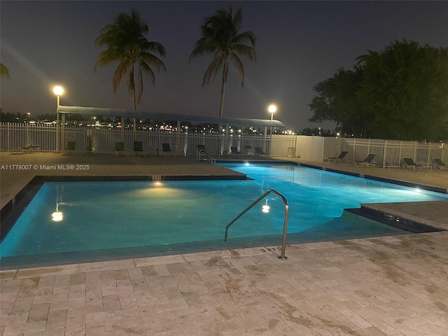 1138 NW 124th Ave Unit 2301, Miami, FL 33182 - pool at night featuring a community pool, a patio area, and fence