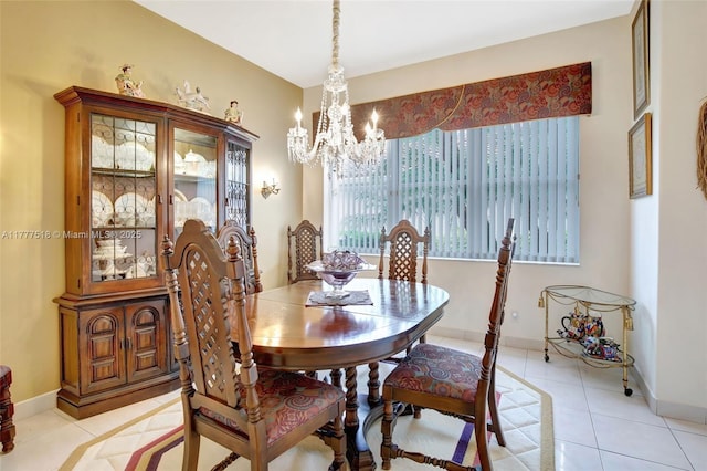 dining room with light tile patterned floors, a notable chandelier, and baseboards
