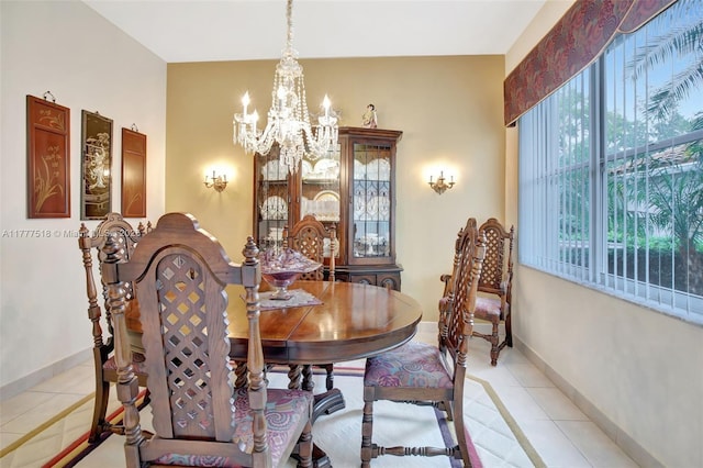 dining space featuring light tile patterned floors, baseboards, and a chandelier