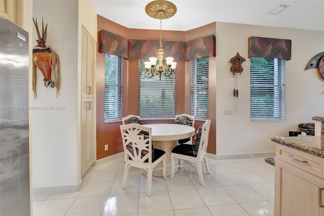 dining area featuring a chandelier, visible vents, baseboards, and light tile patterned flooring