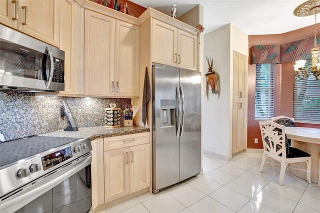 kitchen featuring backsplash, light tile patterned flooring, a chandelier, and stainless steel appliances