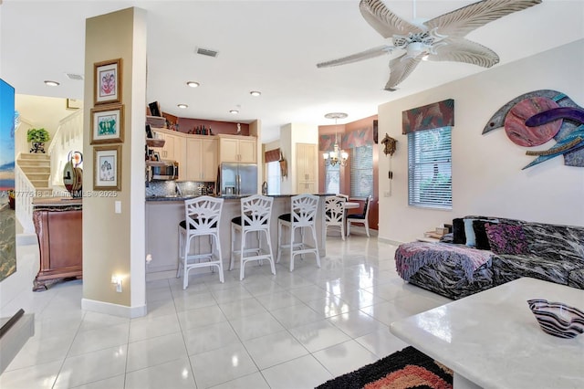 living area with ceiling fan with notable chandelier, light tile patterned floors, baseboards, and recessed lighting