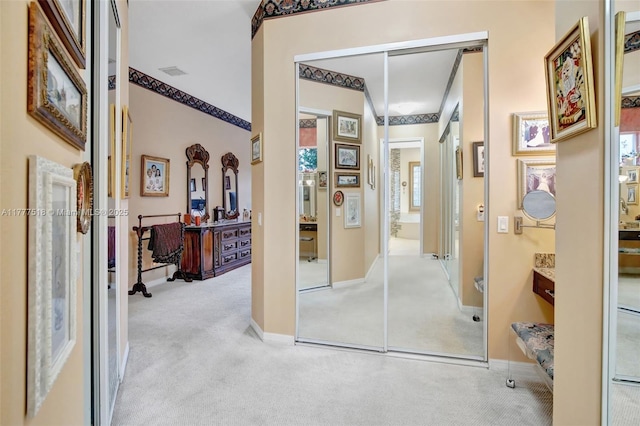 hall featuring carpet, visible vents, and baseboards