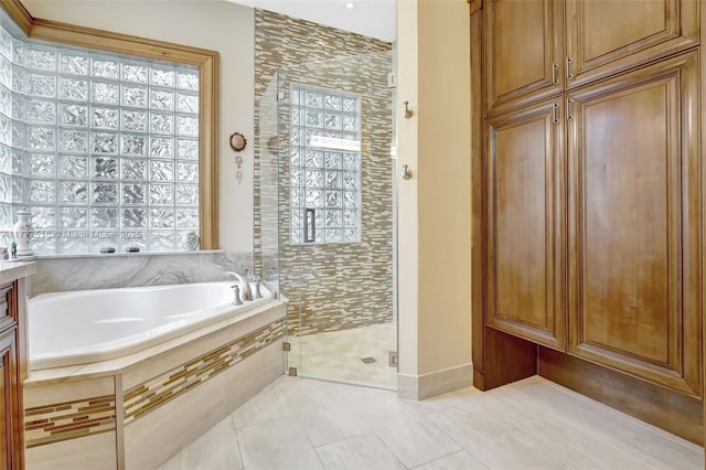 bathroom featuring a shower stall, a bath, and tile patterned flooring