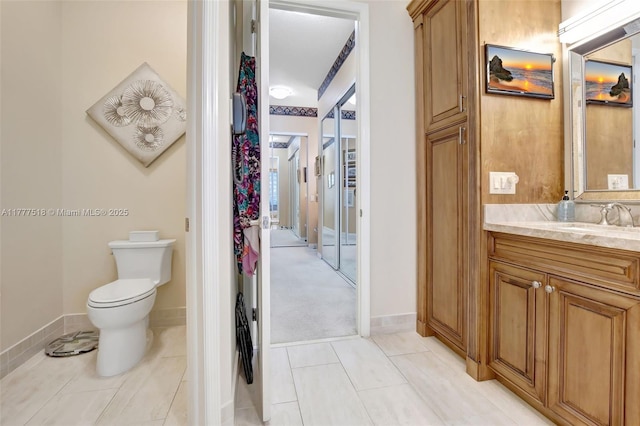bathroom with toilet, tile patterned floors, vanity, and baseboards