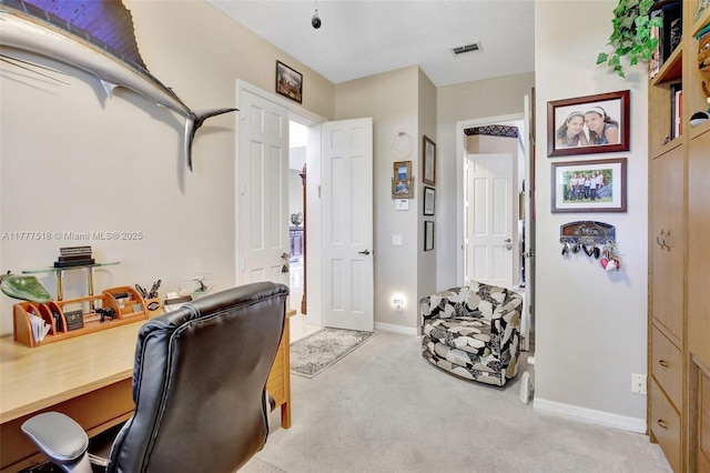 office area featuring light carpet, visible vents, and baseboards