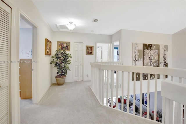 hallway featuring carpet flooring, visible vents, and baseboards