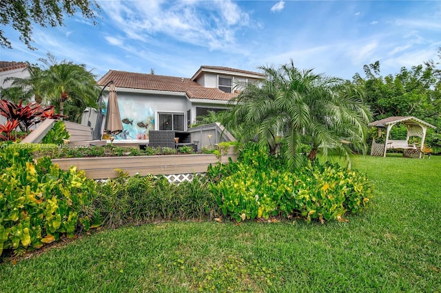 exterior space featuring a yard, a gazebo, stucco siding, and a tiled roof