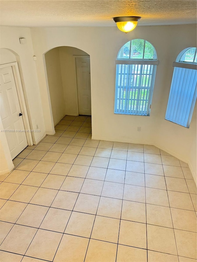 5031 SW 135th Ave Unit 5031, Miramar, FL 33027 - empty room featuring light tile patterned floors, a textured ceiling, and arched walkways
