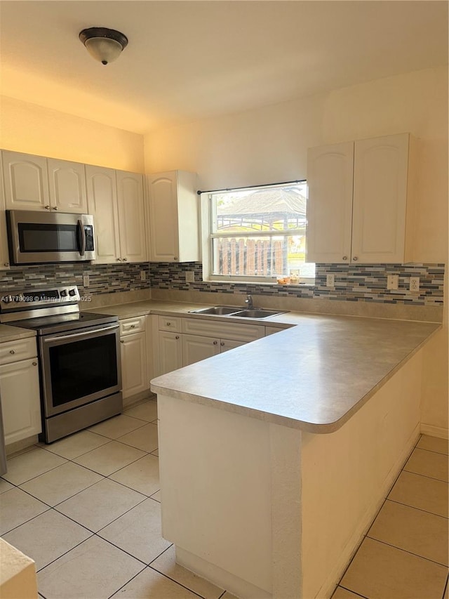 5031 SW 135th Ave Unit 5031, Miramar, FL 33027 - kitchen with appliances with stainless steel finishes, a peninsula, a sink, and decorative backsplash
