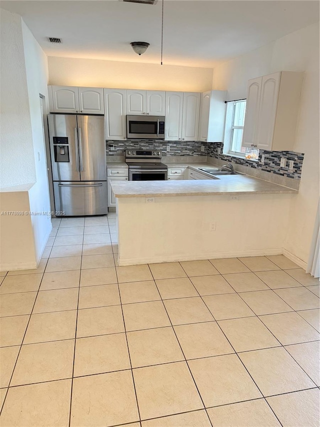 5031 SW 135th Ave Unit 5031, Miramar, FL 33027 - kitchen with appliances with stainless steel finishes, backsplash, a peninsula, light countertops, and light tile patterned flooring