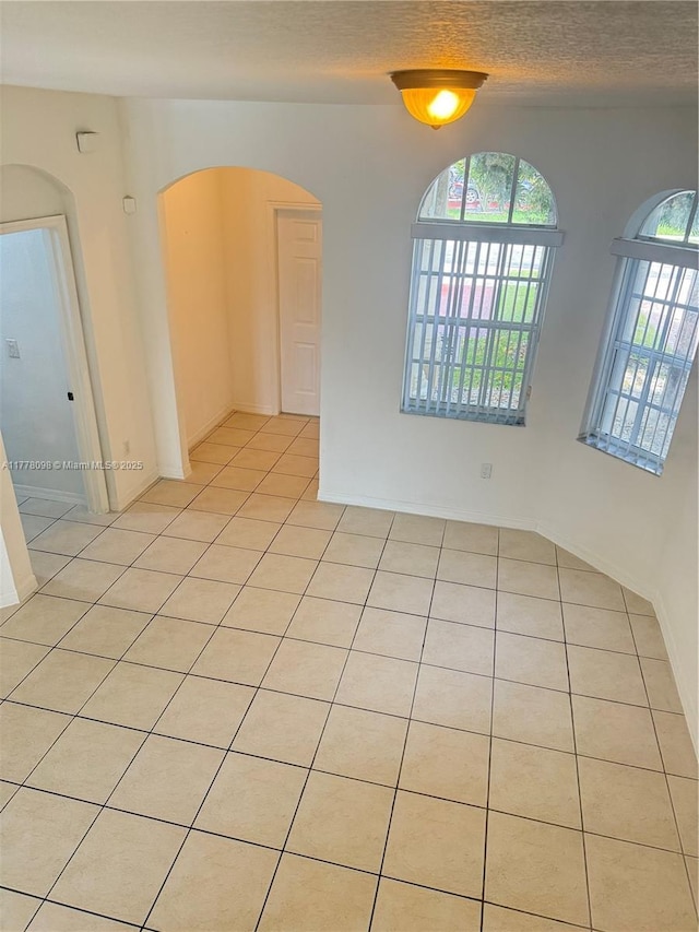 5031 SW 135th Ave Unit 5031, Miramar, FL 33027 - unfurnished room with arched walkways, light tile patterned floors, and a textured ceiling