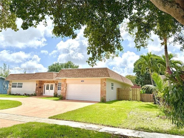 view of front of property with stucco siding, driveway, fence, and a front lawn