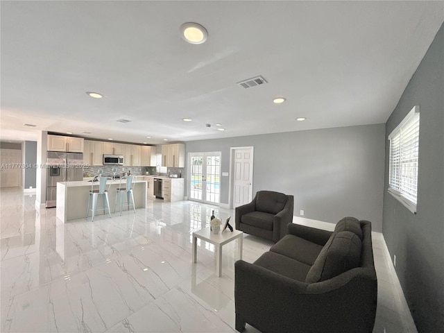 living area with marble finish floor, baseboards, visible vents, and recessed lighting