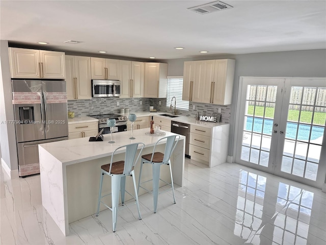 kitchen featuring a sink, visible vents, stainless steel appliances, and backsplash