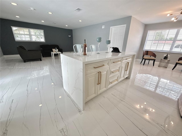 kitchen with open floor plan, recessed lighting, a kitchen island, visible vents, and light stone countertops