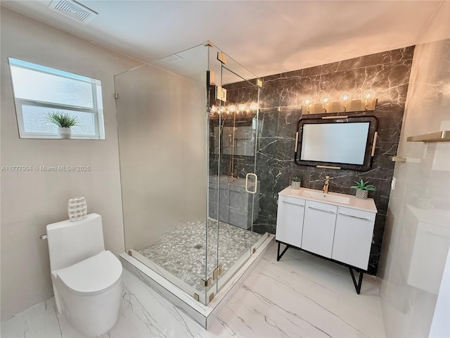 full bath featuring a stall shower, vanity, marble finish floor, visible vents, and tile walls
