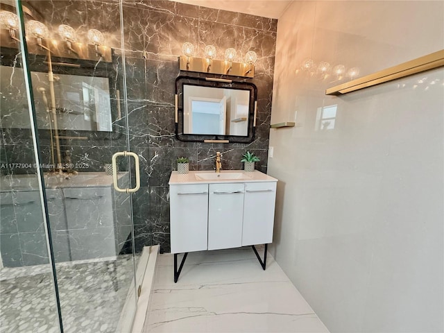 bathroom featuring marble finish floor, vanity, tile walls, and a marble finish shower