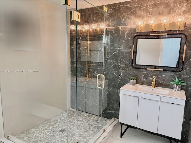 full bath featuring marble finish floor, tile walls, a stall shower, and vanity