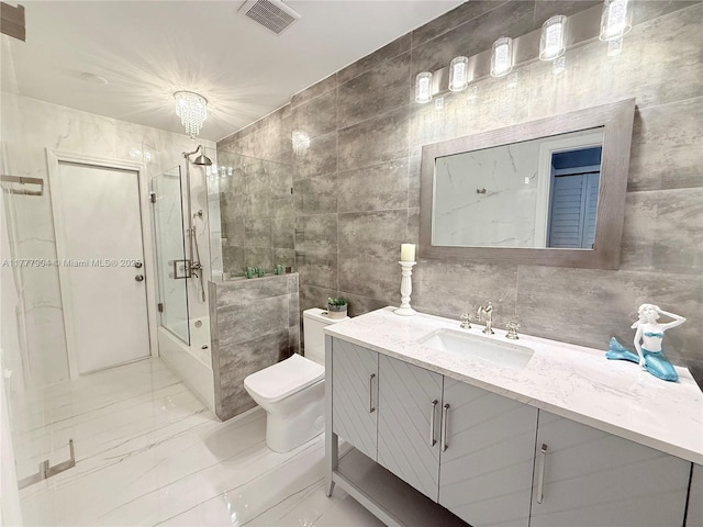 full bathroom with tile walls, visible vents, marble finish floor, toilet, and enclosed tub / shower combo