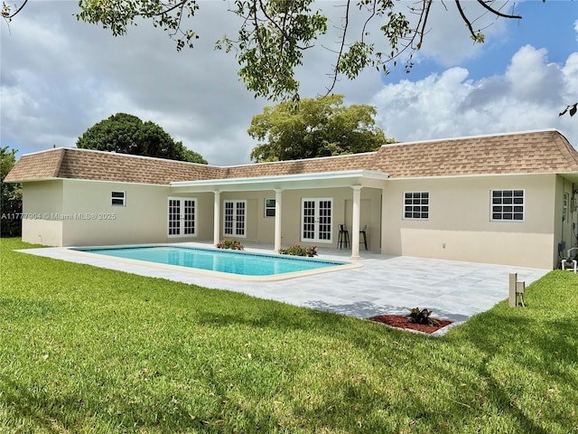 back of house featuring a lawn, stucco siding, a patio, and french doors