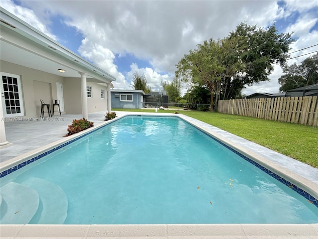 view of pool featuring a lawn, a fenced in pool, a fenced backyard, and a patio area