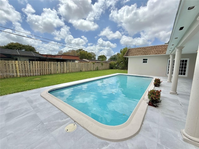 view of swimming pool featuring a patio area, a lawn, fence, and a fenced in pool