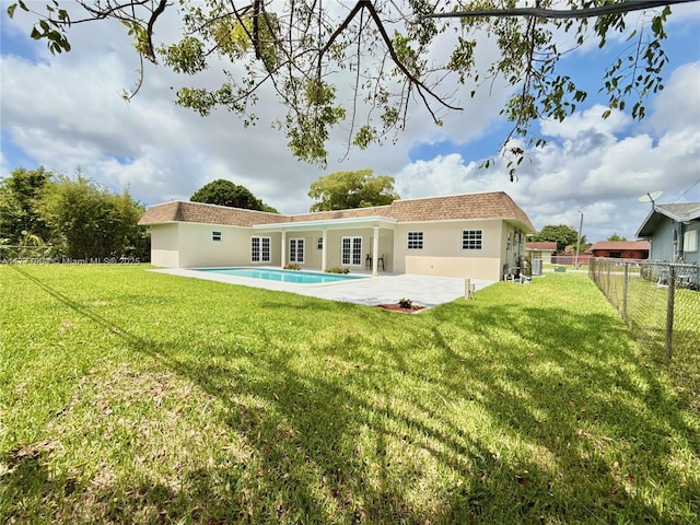 rear view of house with a fenced backyard, stucco siding, a yard, and a patio