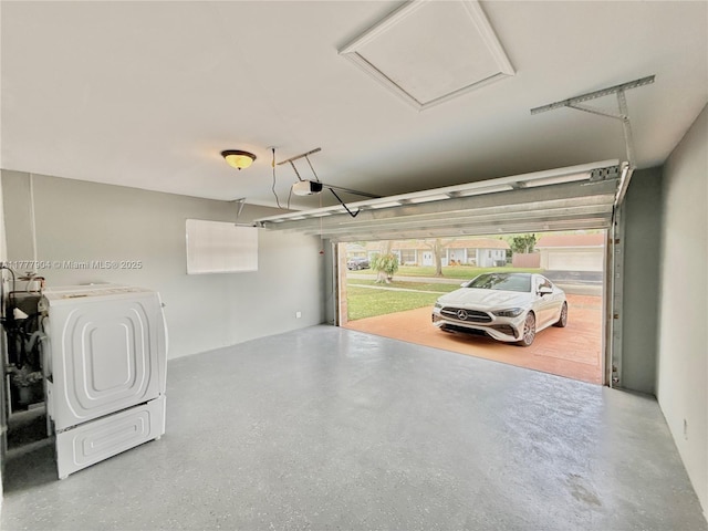 garage featuring washing machine and clothes dryer and a garage door opener