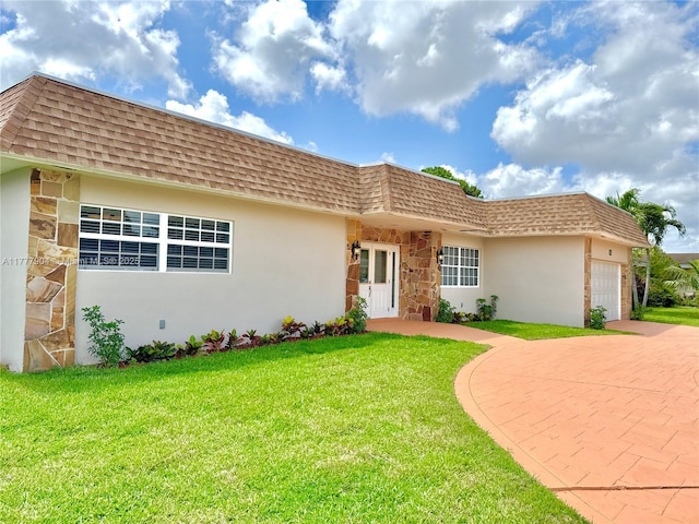 view of front of home with driveway, a front yard, stone siding, stucco siding, and an attached garage