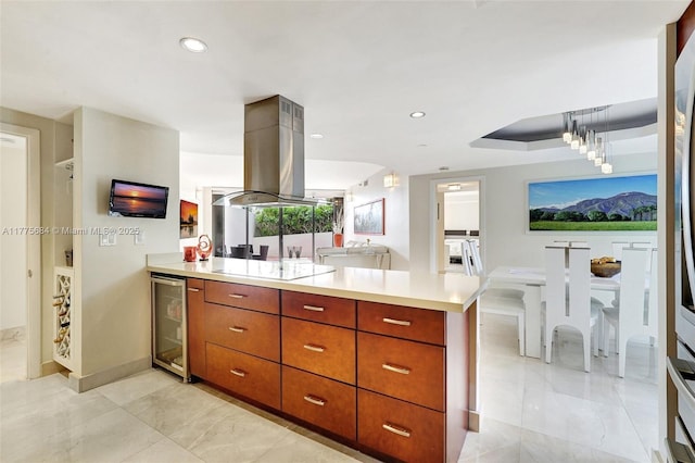 4000 Island Blvd Unit 402, Aventura, FL 33160 - kitchen with a peninsula, light countertops, beverage cooler, brown cabinets, and island range hood
