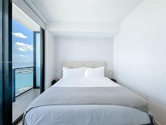 bedroom with wood finished floors and access to exterior