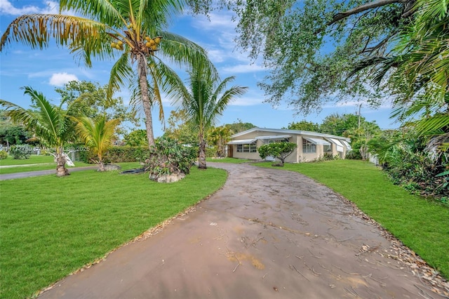 view of front of property featuring aphalt driveway and a front lawn