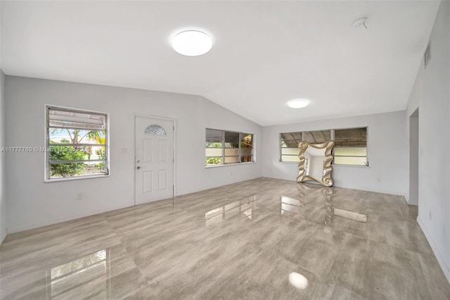 unfurnished living room featuring visible vents, a wealth of natural light, and vaulted ceiling