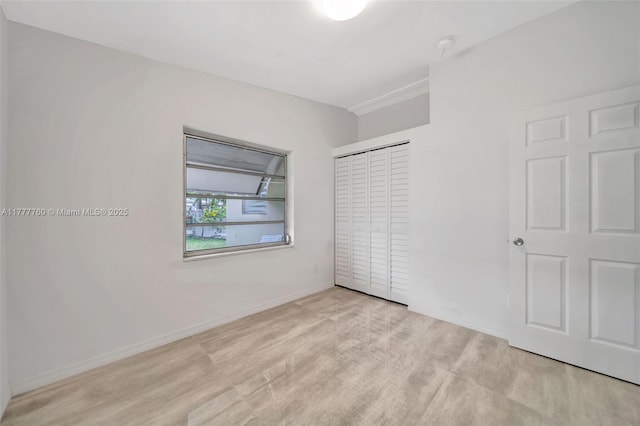 unfurnished bedroom with a closet and baseboards