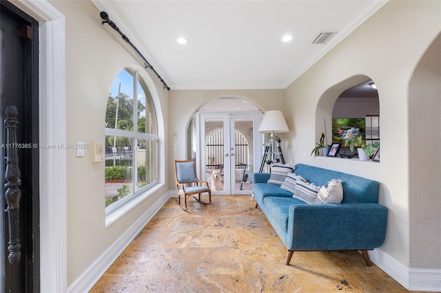 sitting room featuring baseboards, plenty of natural light, and stone tile flooring