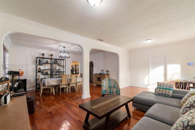 living area featuring a textured ceiling, wood-type flooring, visible vents, crown molding, and arched walkways