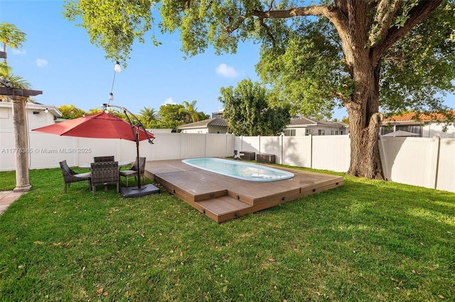 view of yard with a fenced in pool, a wooden deck, and a fenced backyard