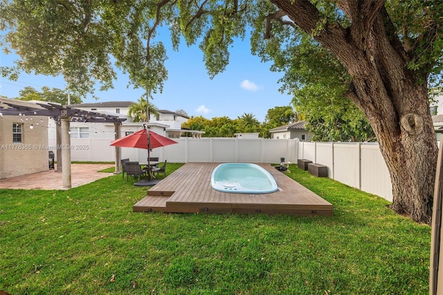 view of swimming pool with a hot tub, a pergola, a fenced backyard, a wooden deck, and a lawn