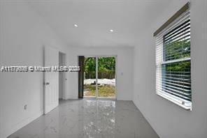 spare room with marble finish floor
