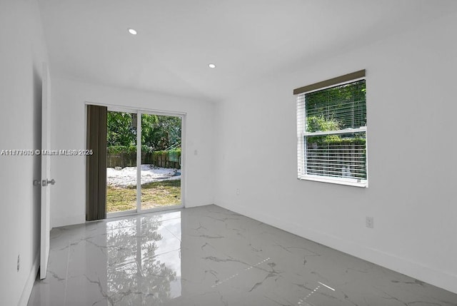 empty room with recessed lighting, marble finish floor, and baseboards