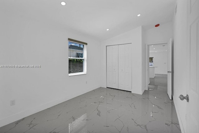 unfurnished bedroom featuring a closet, recessed lighting, marble finish floor, and baseboards
